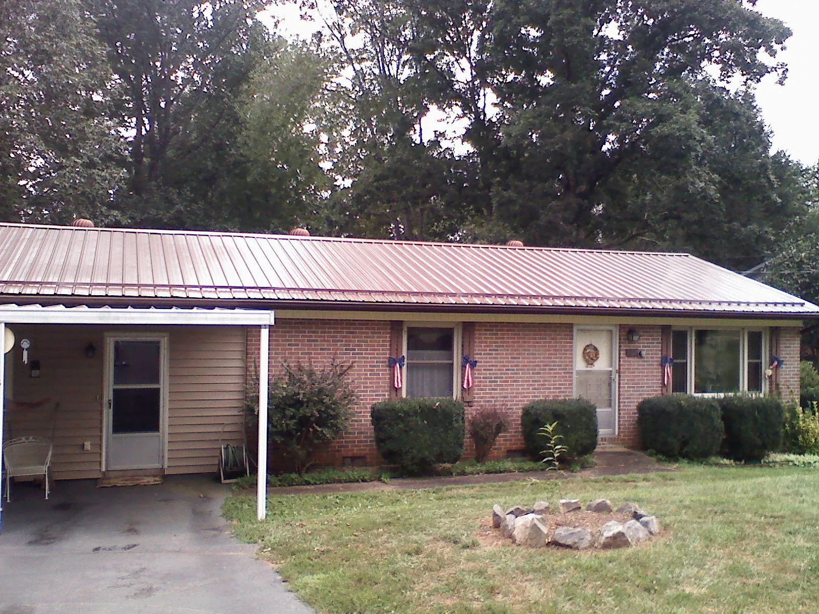Bronze metal roof and carport on a brick ranch home — Roof Repair work by our crew in Durham